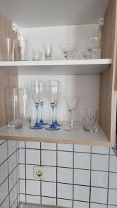a row of wine glasses sitting on a shelf at 3: Einfache 1-Zimmer Wohnung in Bad Wörishofen in Bad Wörishofen
