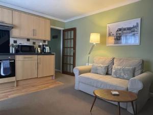 a living room with a couch and a table at Comfortable and spacious apartment with parking in Canterbury