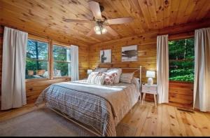 1 dormitorio con 1 cama y ventilador de techo en Sunset Peak - Treehouse - Kid Zone -FirePit-HotTub, en Ellijay