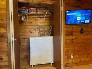 armario con TV y cómoda blanca en Sunset Peak - Treehouse - Kid Zone -FirePit-HotTub, en Ellijay