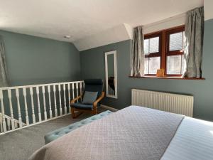 a bedroom with a bed and a chair at Comfortable and spacious apartment with parking in Canterbury