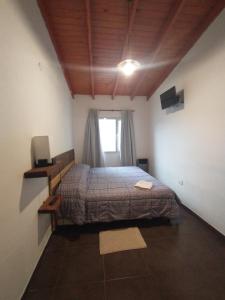 1 dormitorio con cama y ventana en Departamento full con estacionamiento privado en Río Gallegos