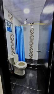 uma casa de banho com um WC e um chuveiro azul em Departamento amoblado en Kennedy central em Bogotá