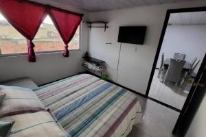 a small bedroom with a bed and a window at Departamento amoblado en Kennedy central in Bogotá