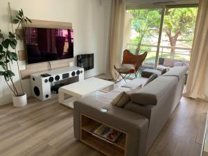 a living room with a couch and a tv at Cosy Flat Cannes in Le Cannet