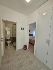 a bathroom with a toilet and a bedroom with a bed at Apartment Marija in Sali