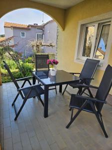 a patio with a table and chairs and a window at Apartment Marija in Sali