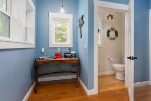 a blue bathroom with a table and a toilet at The TreeHouse by the Sea in Carolina Beach
