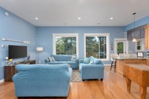 a blue living room with two blue couches and a kitchen at The TreeHouse by the Sea in Carolina Beach