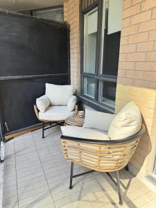 two chairs sitting on a patio next to a building at Boutique Suite in Downtown Toronto, Free Parking! in Toronto