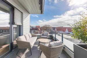 einen Balkon mit Stühlen, einem Tisch und Aussicht in der Unterkunft Penthouse Horizont in Husum