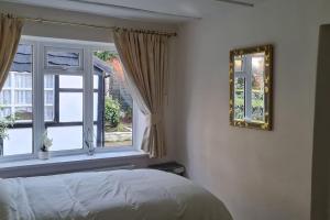 a bedroom with a bed and a window at Shrigley cottage, quirky & quiet in Macclesfield