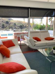 a living room with two white couches and red pillows at Villa de luxe vue mer et piscine privée casa de Palma à Torrox Costa in Torrox Costa