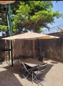 einen Tisch und zwei Stühle unter einem Schirm in der Unterkunft Résidence privée in Conakry