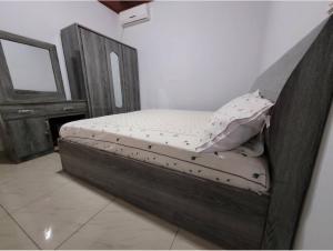 - un lit en bois dans une chambre avec un miroir dans l'établissement Résidence privée, à Conakry