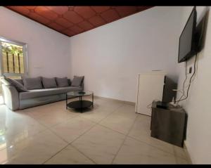 ein Wohnzimmer mit einem Sofa und einem Flachbild-TV in der Unterkunft Résidence privée in Conakry