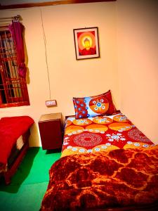 a bedroom with a bed with a colorful comforter at The Kashi Baba Homestay in Dharamshala