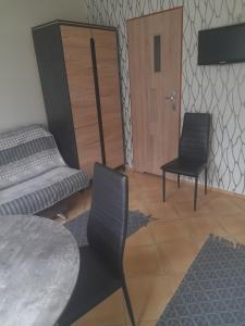 een kamer met 2 stoelen en een tafel en een deur bij Pokoje gościnne przy Kochanowskiego in Mielno