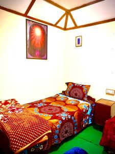 a bedroom with a bed with a colorful comforter at The Kashi Baba Homestay in Dharamshala