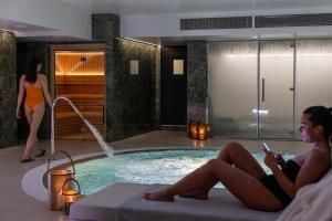 zwei Frauen in einem Swimmingpool in einem Hotel in der Unterkunft Hotel Afonso V & SPA in Aveiro