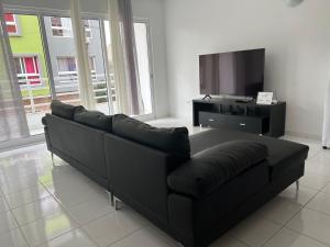 a black couch in a living room with a flat screen tv at PIMONTAPARTMENTS in Espargos