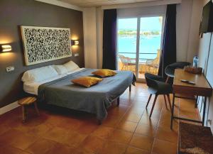 a bedroom with a bed and a view of the ocean at Hostal Bahía Azul in Portocolom