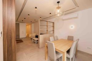 een eetkamer met een houten tafel en stoelen bij Swieqi 3 bedroom apartment (4) in Is-Swieqi