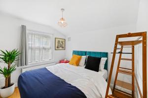 - une chambre avec un lit bleu et blanc et une échelle dans l'établissement Cosy Urban Oasis 2 Bedroom Flat in Tottenham ( Sleeps 5 People ), à Londres