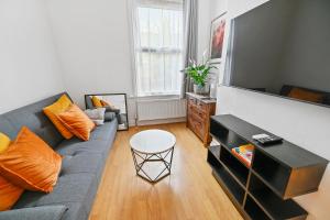 salon z kanapą i stołem w obiekcie Cosy Urban Oasis 2 Bedroom Flat in Tottenham ( Sleeps 5 People ) w Londynie