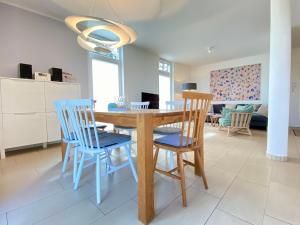 een eetkamer en een woonkamer met een houten tafel en stoelen bij Ferienwohnung Koje 2 in Ostseebad Karlshagen