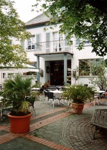 ein Gebäude mit einer Terrasse mit Tischen und Stühlen in der Unterkunft Hotel Louis Müller in Bitburg