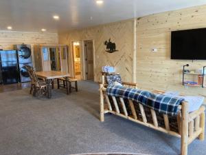 Habitación con pared de madera, cama y mesa. en Keweenaw Waters Resort, en Houghton