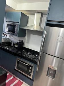 a kitchen with a stainless steel refrigerator and a microwave at ALUGUEL TEMPORADA TECNOSHOW in Rio Verde