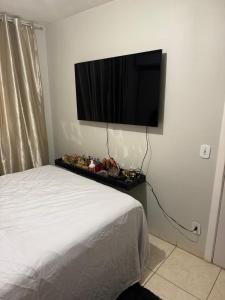 a bedroom with a bed and a flat screen tv on the wall at ALUGUEL TEMPORADA TECNOSHOW in Rio Verde