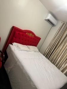 a bed with a red headboard in a room at ALUGUEL TEMPORADA TECNOSHOW in Rio Verde