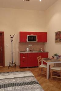 eine Küche mit roten Schränken und einem Tisch mit einer Mikrowelle in der Unterkunft Stella apartments in Prag