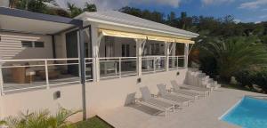 a house with chairs and a swimming pool at Villa Blue Marine in Deshaies