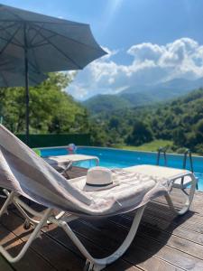 a lounge chair with an umbrella next to a pool at Aphrodite Hills Apartments-Stara Planina in Crni Vrh