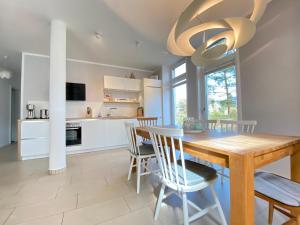 een keuken en eetkamer met een houten tafel en stoelen bij Ferienwohnung Koje 2 in Ostseebad Karlshagen
