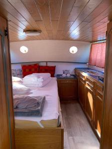 a small bedroom with a bed and a kitchen at Stahlschiff DORINA in Sassnitz