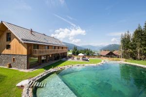 a house with a large swimming pool next to a building at Lerchpeuntgut Alpenfreud Apartments in Tamsweg