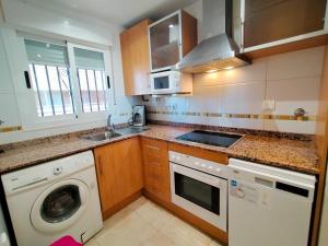 a kitchen with a washing machine and a sink at ACV - Jardines del Mar II-2ª linea planta 1 Sur in Oropesa del Mar