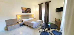 una camera d'albergo con letto, tavolo e sedie di La Maison Rose a Maiori