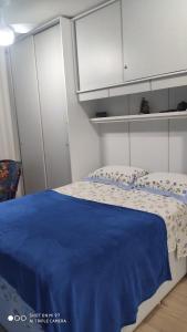 1 dormitorio con 1 cama con manta azul en Apt 2 qtos, prox. ao Rio centro, Jun, e P. Olimpic en Río de Janeiro