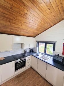 a kitchen with white cabinets and a wooden ceiling at Otter 3 HuntersMoon-Warminster-Bath-Salisbury in Warminster