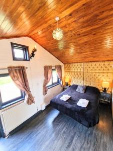 Un dormitorio con una cama grande en una habitación con techos de madera. en Otter 3 HuntersMoon-Warminster-Bath-Salisbury en Warminster
