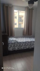 1 dormitorio con cama y ventana en Apt 2 qtos, prox. ao Rio centro, Jun, e P. Olimpic en Río de Janeiro