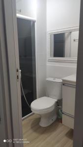 a bathroom with a white toilet and a mirror at Apt 2 qtos, prox. ao Rio centro, Jun, e P. Olimpic in Rio de Janeiro