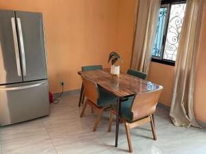 a dining room table with chairs and a refrigerator at RESIDENCE ROYAL in Douala