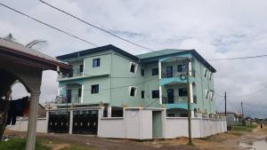 a green building with a blue roof at RESIDENCE ROYAL in Douala